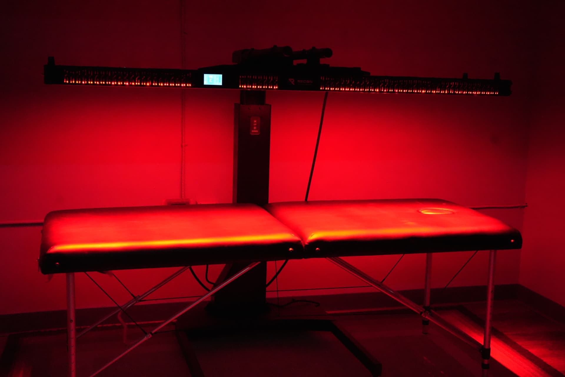 Red light therapy panel over a treatment table at Arsenal Health