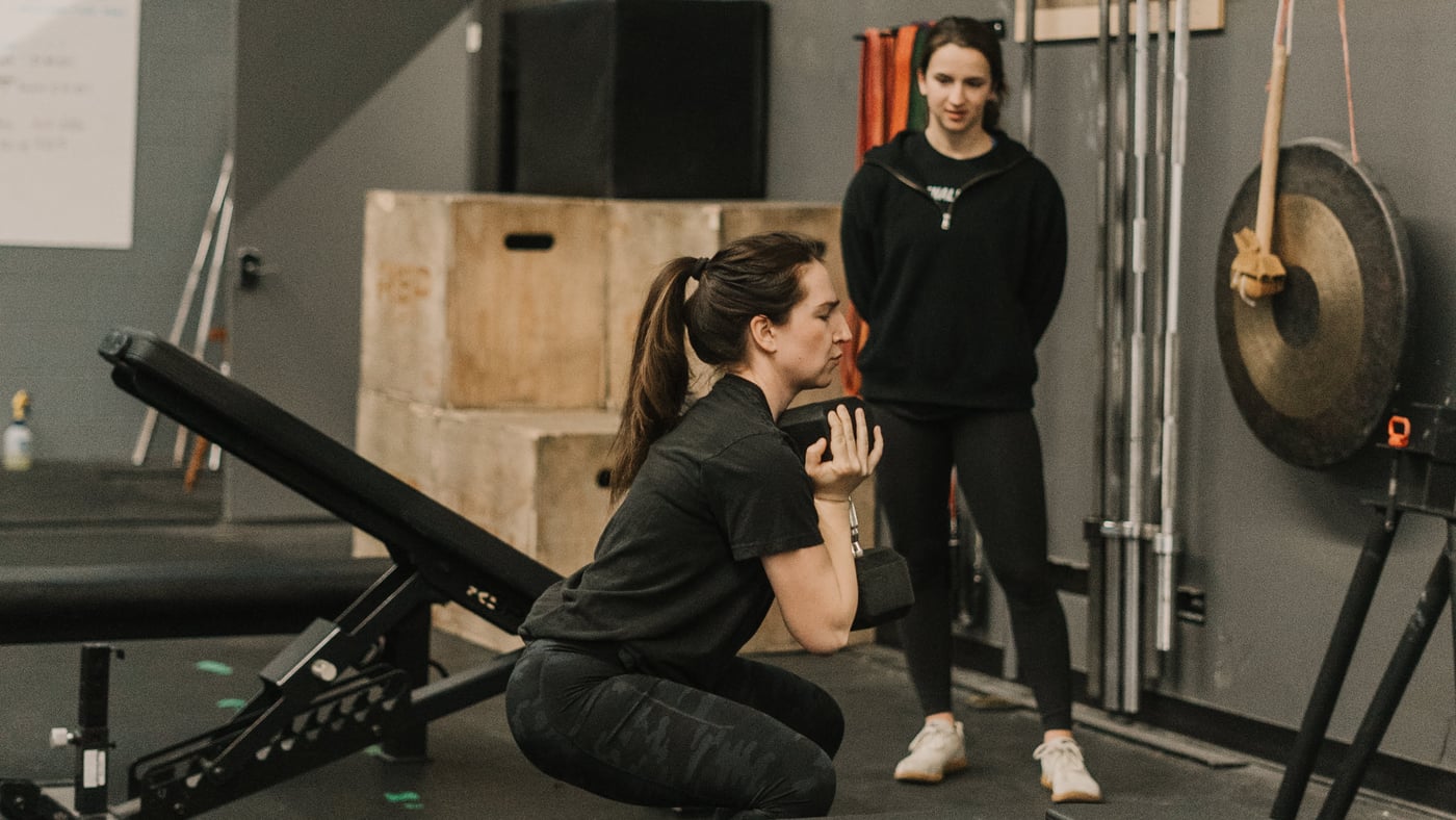Personal trainer working with a client on knee pain recovery at Arsenal Health Denver